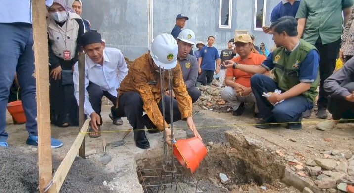 Bupati Madiun sedang melaksanakan peletakan batu pertama program renovasi rumah RTLH/RMOLJatim